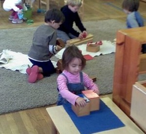 children work independently and in groups in the smoothly functioning primary Montessori classroom