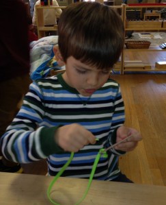 Lacing cards boy works diligently at lacing a card