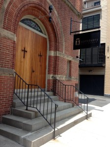 The exterior of Sanctuary Bodyworks features a sign approved by the historical society.