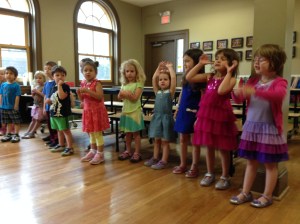 Primary students practice recognizing the notes of the music scale and demonstrating them with hand gestures.